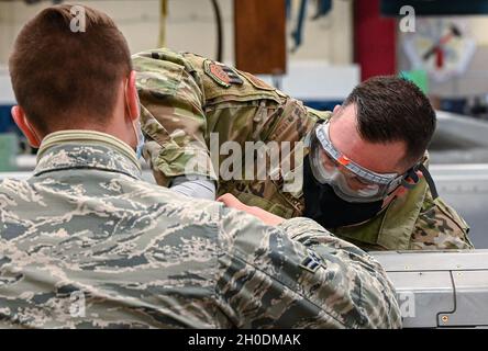 Airman 1a classe Gary Farris, capo squadra a baia bassa di 2 munizioni Squadron, osserva il Colon Mark Dmytryszyn, comandante dell'ala della seconda bomba, mentre esegue la manutenzione su un missile da crociera lanciato in aria AGM-86 alla base dell'aeronautica militare di Barksdale, la. 3 febbraio 2021. I bombardieri B-52H trasportano sei missili da crociera su ciascuno dei due piloni montati esternamente e otto internamente su un lanciatore rotante, dando al B-52H una capacità massima di 20 missili per aeromobile. Foto Stock