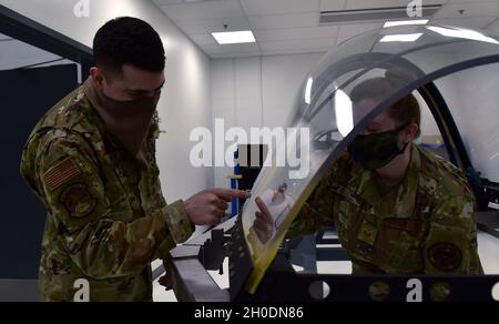 U.S. Air Force staff Sgt. Antonio Jimenez, a sinistra, un 372o Squadrone di addestramento, distaccamento 25, F-35A Lightning II Egress Systems istruttore, ispeziona la flessibile carica a forma lineare (FLSC) con lo staff Sgt. Sara Gould, un 372o TRS, Det. 25, F-35A Low Observable Aircraft Structural Maintenance istruttore, presso il distaccamento di addestramento sul campo alla base dell'aeronautica militare Eielson, Alaska, 3 febbraio 2021. Agli studenti di uscita è stato insegnato come installare l'FLSC per garantire le funzioni corrette in modo che i piloti possano espellere in sicurezza da un aereo in caso di emergenza. Foto Stock