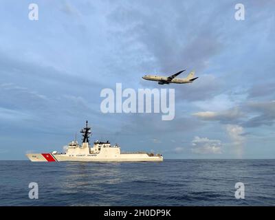 L'equipaggio della Cutter Cutter Kimball della Guardia Costiera (WMSL-756) e un equipaggio Navy P-8 Poseidon cerca un marinaio mancante al largo di Guam, 4 febbraio 2021. Il marinaio a bordo della nave da pesca Miyamaru No. 18 tentò di nuotare verso una vicina nave da pesca. Foto Stock