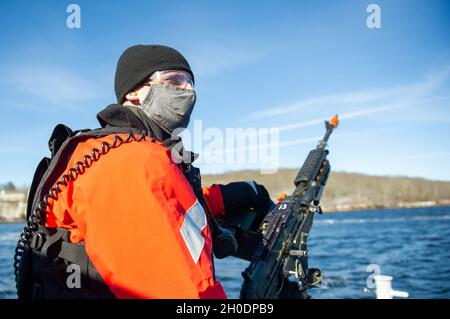 210204-N-EJ843-0026 GROTON, Conn. (Feb 04, 2021) Master-at Arms Seaman Apprentice Gabriel Dawghan, assegnato alla base navale sottomarina New London's Harbour Patrol Unit, equipaggia una mitragliatrice M240 durante un attacco simulato di una piccola barca a sostegno dell'esercizio Citadel Shield-Solid Curtain 2021 (CS-SC21). CS-SC21 è un esercizio di protezione della forza in due parti che viene condotto a livello nazionale sulle installazioni della Marina. L'esercizio annuale non è in risposta a una minaccia specifica, ma viene utilizzato per valutare la disponibilità dei programmi di sicurezza della flotta e dell'installazione. Foto Stock