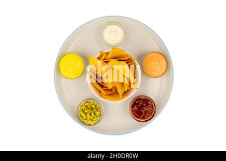 Ciotole di salsa messicana su un piatto di ceramica con tortilla chips al centro. Foto Stock