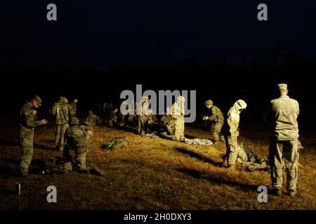 I soldati dell'esercito degli Stati Uniti conducono un controllo di funzioni dopo una marcia di 12-miglio del ruck durante le valutazioni del badge esperto di fanteria e del badge soldato esperto a Fort Benning, Georgia, 5 febbraio 2021. La formazione e i test della BEI e del ESB sono estremamente impegnativi, orientati alla missione e condotti in condizioni realistiche. Foto Stock