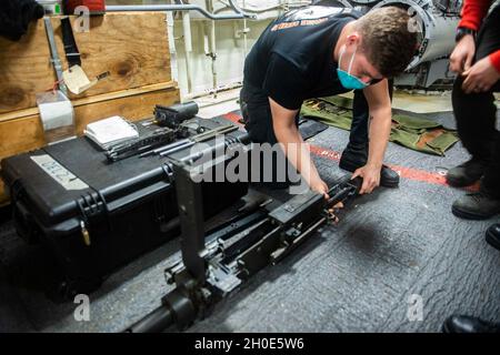 210207-N-RG587-1015 OCEANO ATLANTICO (DAL 7, 2021) Aviation Electronics Technician Petty Officer 2a classe Corey Dibaise effettua il pre-volo su una mitragliatrice calibro .50 a bordo dell'incrociatore missilistico guidato classe Ticonderoga USS Vella Gulf (CG 72) 7 febbraio 2021. Il Golfo di Vella è in corso nell'Oceano Atlantico e svolge le sue attività nell'ambito del gruppo Dwight D. Eisenhower Carrier Strike Group. Foto Stock