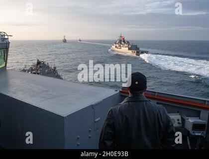 210209-N-RG171-0354 MAR NERO (DAL 9, 2021) CMdR. Matthew Curnen, comandante del cacciatorpediniere missilistico guidato di classe Arleigh Burke USS Donald Cook (DDG 75), guarda come la marina turca di classe Yavuz TCG Turgutreis (F-241), medio, E la fregata turca di classe Barbaros TCG Orucreis (F-245), destra, partecipano ad un esercizio di passaggio con il Donald Cook e il cacciatorpediniere missilistico guidato di classe Arleigh Burke USS Porter (DDG 78) nel Mar Nero, 9 febbraio 2021. Donald Cook, dispiegato a Rota, in Spagna, è in pattuglia nell'area della Sesta flotta degli Stati Uniti di operazioni a sostegno degli alleati regionali Foto Stock