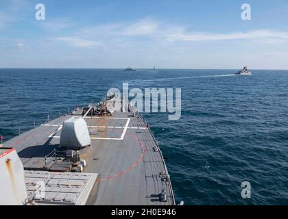 210209-N-RG171-0295 MAR NERO (DAL 9, 2021) il cacciatorpediniere missilistico guidato di classe Arleigh Burke USS Porter (DDG 78), al centro, la fregata della marina turca di classe Barbaros TCG Orucreis (F-245), a sinistra, E la marina turca di classe Yavuz TCG Turgutreis (F-241) naviga in formazione con il cacciatorpediniere missilistico guidato di classe Arleigh Burke USS Donald Cook (DDG 75) durante un esercizio fotografico nel Mar Nero, 9 febbraio 2021. Donald Cook, dispiegato a Rota, in Spagna, è in pattuglia nell'area della Sesta flotta degli Stati Uniti di operazioni a sostegno di alleati e partner regionali e della sicurezza nazionale degli Stati Uniti in Europa e Africa. Foto Stock