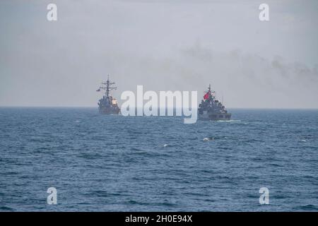 210209-N-RG171-0086 MAR NERO (DAL 9, 2021) il cacciatorpediniere missilistico guidato di classe Arleigh Burke USS Porter (DDG 78), a sinistra, la fregata della marina turca di classe Barbaros TCG Orucreis (F-245) naviga in formazione durante un esercizio fotografico nel Mar Nero, 9 febbraio 2021. Porter, dispiegato a Rota, in Spagna, è in pattuglia nell'area della Sesta flotta degli Stati Uniti di operazioni a sostegno di alleati e partner regionali e la sicurezza nazionale degli Stati Uniti in Europa e Africa. Foto Stock