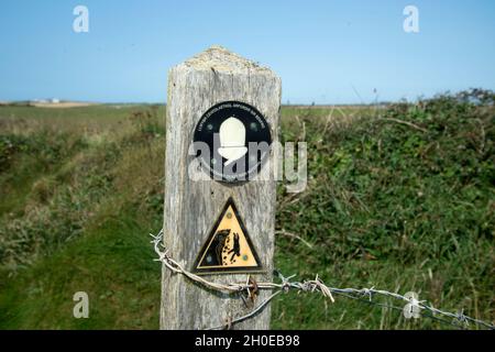 Galles agosto 2021. Pembrokeshire. Dale. Un cartello sul sentiero costiero che avverte delle cadute di roccia Foto Stock