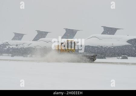 Gli aerei C-5M Super Galaxy coperti di neve si siedono sulla linea di volo come spazzaneve dal 436esimo Squadrone ingegnere civile libera la neve alla base dell'aeronautica di dover, Delaware, 11 febbraio 2021. Mentre Winter Storm Roland produceva un mix di precipitazioni, la base continuava le normali operazioni e si preparava per ulteriori previsioni di nevicate. Foto Stock