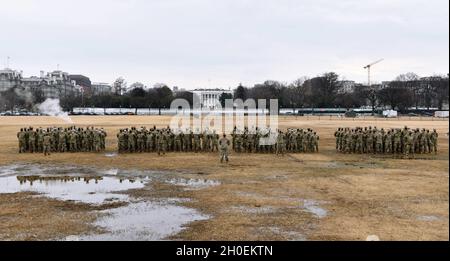 Soldati e Airmen statunitensi con la Guardia Nazionale del Massachusetts, assegnati alla Bravo Company, Task Force Freedom, si levano in piedi alla parata di riposo a Washington, D.C., 14 febbraio 2021. La Guardia Nazionale è stata invitata a continuare a sostenere le forze dell'ordine federali con sicurezza, comunicazioni, medicina, evacuazione, logistica, E supporto alla sicurezza per enti statali, distrettuali e federali fino a metà marzo. Foto Stock