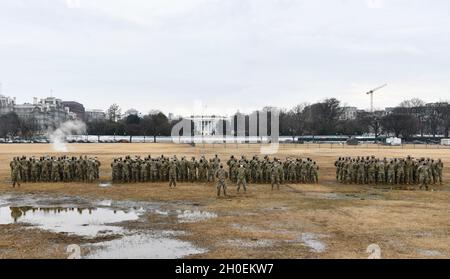 Soldati e Airmen statunitensi con la Guardia Nazionale del Massachusetts, assegnati alla Bravo Company, Task Force Freedom, si levano in piedi alla parata di riposo a Washington, D.C., 14 febbraio 2021. La Guardia Nazionale è stata invitata a continuare a sostenere le forze dell'ordine federali con sicurezza, comunicazioni, medicina, evacuazione, logistica, E supporto alla sicurezza per enti statali, distrettuali e federali fino a metà marzo. Foto Stock