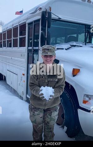 Nebraska Army National Guard SPC. Grace Zelasney tiene un po' di neve nelle sue mani dopo il ritorno in Nebraska da un esercizio di tre settimane da combattimento, il 14 febbraio 2021, a Fort Riley, Kansas. Quasi 200 soldati della Nebraska Army National Guard's Headquarters and Headquarters Company, 67a Stefth Manage Enhancement Brigade e 234th Signal Company hanno partecipato all'allenamento, partendo dal Nebraska dopo la più grande tempesta invernale di neve degli ultimi decenni e tornando a temperature fredde record. (Nebraska National Guard video ancora di Sgt. Lisa Crawford) Foto Stock