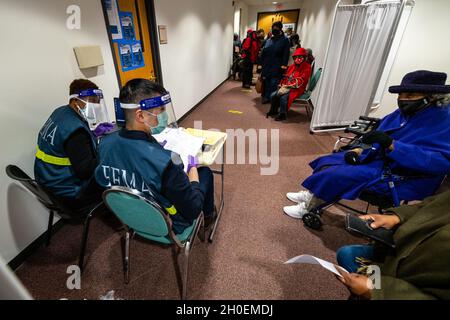 Somerset, N.J., 15 febbraio 2021—il personale FEMA, insieme ai membri del Dipartimento della Difesa, della NJ EOC e dei Troopers dello Stato del New Jersey, fornisce supporto alle vaccinazioni COVID-19 ai membri della comunità locale. Patrick Cheng e Alizeta Diallo, della Regione 2, in uno dei check-in di registrazione. FEMA sta lavorando con i governi statali, locali, tribali e territoriali sulla necessità critica di aprire i centri di vaccinazione nelle comunità svantaggiate. C. Wilsey/FEMA Foto Stock