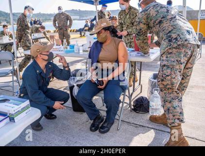 OKINAWA, Giappone (Feb 16, 2021) il comandante Andrew J. Tyler, di Oakland, California, consiglia l'esperto culinario Seaman Florence Ogba, di Jacksonville, Fl., mentre si prepara a ricevere il primo round del vaccino Moderna COVID-19. Entrambi sono assegnati alla nave di sbarco anfibio USS Germantown (LSD 42). Germantown, parte di Amphibious Squadron 11, insieme alla 31esima unità Marine Expeditionary, sta operando nell'area di responsabilità della 7th Fleet degli Stati Uniti per migliorare l'interoperabilità con alleati e partner e servire come una forza di risposta pronta per difendere la pace e la stabilità nell'Ind Foto Stock