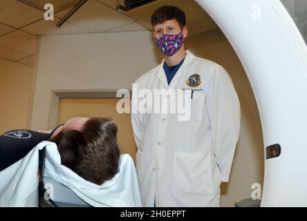 JACKSONVILLE, Florida (dal 16, 2021) - Lt. CMdR. Andrew Westmoreland, radiologo del Naval Hospital di Jacksonville, discute con un paziente una scansione TC. Nativo di Oxford, Mississippi, si è laureato in medicina presso l'Università del Mississippi. Westmoreland afferma: "Il mio team garantisce che siano state adottate adeguate misure di pianificazione, manning e sicurezza contro le radiazioni, in modo da poter interpretare in modo rapido e accurato gli studi di radiologia di routine e emergenti per i pazienti presso le cliniche ospedaliere e di ramo". Foto Stock