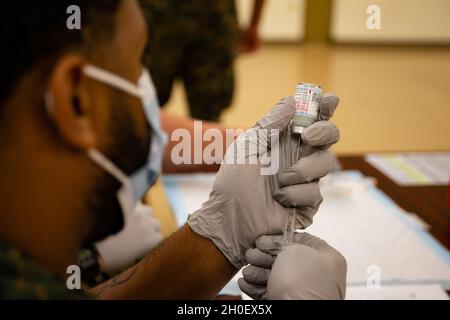 U.S. Navy Seaman Isaiah Miller, corpsman ospedaliero, 1° battaglione, 3d Marines, prepara un ago con il vaccino COVID-19, Marine Corps base Hawaii, 18 febbraio 2021. I marines degli Stati Uniti dal 1/3 alle Hawaii stanno ricevendo il vaccino volontario COVID-19 per proteggere la loro salute e sostenere la prontezza generale del reggimento. Foto Stock