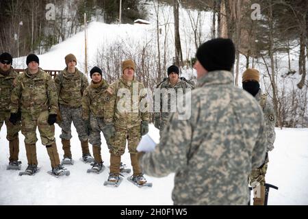 I soldati della Bravo Company, Battaglione tecnico della quarantunesima Brigata, II Team di combattimento della Brigata, X Divisione montagna (li), ascoltano un istruttore della 86a squadra di combattimento della Guardia Nazionale dell'Esercito parlano di tecniche di sensibilizzazione e sopravvivenza alle valanghe presso il Camp Ethan Allen Training Site di Jericho, Vt., 19 febbraio 2021. Come ricompensa per aver completato la sfida D-Series il 9-10 febbraio 2021, e piazzato come uno dei primi tre team, il 41° BEB e altri 10° Mountain Div I soldati hanno l'opportunità di imparare tattiche di guerra di montagna per includere arrampicata su ghiaccio, evacuati vittime Foto Stock