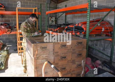 Christian Ernand, pilota, Charlie Company, 2-149 Battaglione di supporto dell'aviazione generale, Texas Army National Guard conta i pacchetti di cibo che saranno consegnati ai texani in risposta a Winter Storm Uri Feb 19.2021, presso la San Antonio Army Aviation Support Facility, Martindale, Texas. Circa 32 soldati dell'unità hanno dichiarato di essere in servizio presso la struttura e hanno eseguito controlli di manutenzione e pianificazione pre-volo al fine di consegnare cibo e acqua alle comunità del Texas. Foto Stock