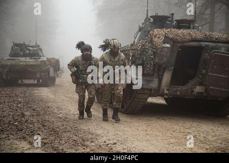 I soldati italiani assegnati alla Bravo Company, 11° Battaglione di Bersaglieri camminano sui loro veicoli dopo un attacco simulato all'imboscata nel Joint multinazionale Readiness Center di Hohenfels Training Area, Germania, 21 febbraio 2021. Combined Resolve XV è un'esercitazione multinazionale diretta dal Dipartimento della sede centrale dell'Esercito, progettata per costruire la prima squadra di combattimento delle Brigate Armored, la disponibilità della prima Divisione Cavalleria e migliorare l'interoperabilità con le forze alleate per combattere e vincere contro qualsiasi avversario. Foto Stock