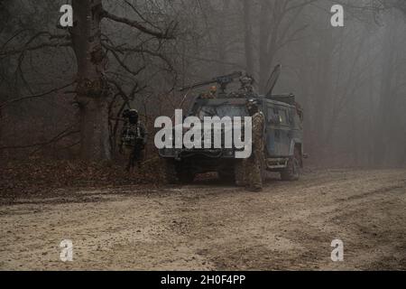 Soldati italiani assegnati alla Bravo Company, 11th Bersaglieri Battaglione fornire la sicurezza dopo un attacco simulato di agguato nel Joint multinazionale Readiness Center in Hohenfels Training Area, Germania, 21 febbraio 2021. Combined Resolve XV è un'esercitazione multinazionale diretta dal Dipartimento della sede centrale dell'Esercito, progettata per costruire la prima squadra di combattimento delle Brigate Armored, la disponibilità della prima Divisione Cavalleria e migliorare l'interoperabilità con le forze alleate per combattere e vincere contro qualsiasi avversario. Foto Stock