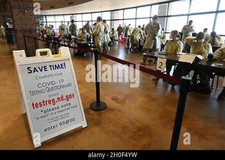 I soldati e gli Airmen della Guardia Nazionale del Nord Dakota si preparano a condurre test volontari BinaxNOW COVID-19 per i possessori di biglietti di calcio Bison della North Dakota state University nella lobby del Fargodome, Fargo, N.D., 21 febbraio 2021. Il test viene offerto ai partecipanti al gioco come servizio comunitario quando entrano nella struttura su richiesta del sindaco Fargo Tim Mahoney. Foto Stock