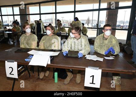 I soldati e gli Airmen della Guardia Nazionale del Nord Dakota si preparano a condurre test volontari BinaxNOW COVID-19 per i possessori di biglietti di calcio Bison della North Dakota state University nella lobby del Fargodome, Fargo, N.D., 21 febbraio 2021. Il servizio di test viene offerto ai partecipanti al gioco quando entrano nella struttura. Foto Stock