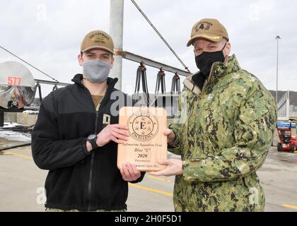 210222-N-GR655-001 GROTON, Conn. (22 febbraio 2021) – Capt. Andrew Miller, commodore for Submarine Squadron (SUBRON) QUATTRO, a destra, presenta il premio Supply 'e' all'equipaggio del sottomarino di classe Virginia USS Vermont (SSN 792), rappresentato dal responsabile della fornitura dell'imbarcazione Lt. j.g. Joseph Prikasky a bordo della base navale sottomarina New London a Groton, Conn., 22 febbraio. Il premio Supply 'e', basato su una valutazione di un anno, riconosce le unità che hanno raggiunto la più alta valutazione complessiva nella preparazione al combattimento e nell'eccellenza della fornitura per ogni squadrone della forza sottomarina. Foto Stock