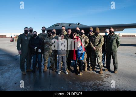 Troy Combs, 325 armi comandante Squadron, si leva con la famiglia e gli amici per una foto dopo aver completato il suo volo finale, noto anche come volo fini, alla base dell'aeronautica di Whiteman, Missouri, 22 febbraio 2021. Il volo fini è una tradizione militare onorata nel tempo che segna l’ultimo volo di un membro dell’equipaggio con un’unità o un pensionamento. Foto Stock