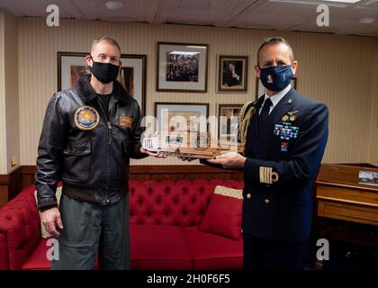 Gianfranco Vizzini, attaccante navale, Right, riceve un regalo per conto del capitano della Marina italiana Giancarlo Ciappina, comandante del portaerei ITS Cavour (CVH 550), dal capitano della Marina americana Cassidy Norman, comandante del portaerei USS John C. Stennis (CVN 74), Come parte di uno scambio di regali nella cabina di porto del capitano, a bordo del John C. Stennis, a Norfolk, Virginia, 22 febbraio 2021. Il John C. Stennis collabora con Newport News Shipbuilding per completare la revisione del complesso di rifornimento in base ai tempi previsti con un equipaggio addestrato, resiliente e coeso. Foto Stock