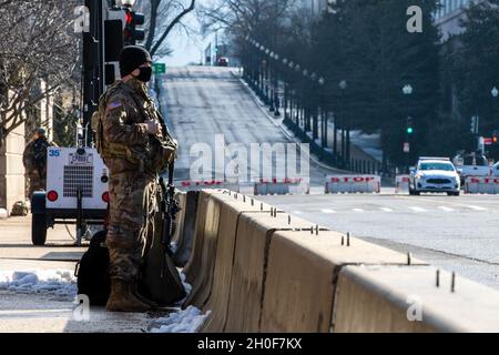 SPC dell'esercito degli Stati Uniti. Steven Phillips, un ingegnere orizzontale con la 1313 Engineer Company, Indiana National Guard, si trova vicino al Campidoglio degli Stati Uniti a Washington, 23 febbraio 2021. La Guardia Nazionale è stata invitata a continuare a sostenere le agenzie federali di polizia con sicurezza, comunicazioni, evacuazione medica, logistica e supporto alla sicurezza per le agenzie distrettuali, statali e federali fino a metà marzo. Foto Stock