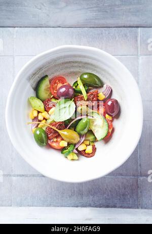 Insalata semplice con olive verdi e Kalamata, cetrioli, pomodori ciliegini e marinati, capperi e peperoni Jalapeno. Foto Stock