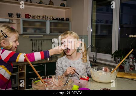 I due ragazzi la preparazione di muffin dolce in cucina Foto Stock