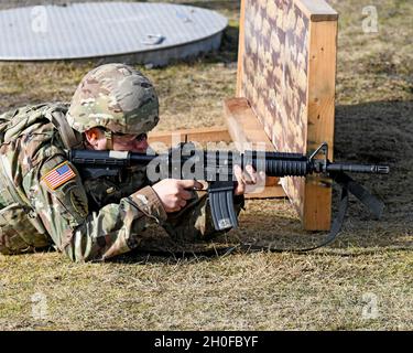 SGT. Prima classe Justin S. Rorex con 1 ° battaglione, 214 reggimento di aviazione, 12 ° combattimento brigata di aviazione, 'Wings of Victory,' durante un esercizio di fuoco dal vivo con M4 Carbine, subito dopo il fuoco, con un caso espulso a mezz'aria. Baumholder Maneuvre Training Area, Range 21, Germania 24 febbraio 2021. Foto Stock