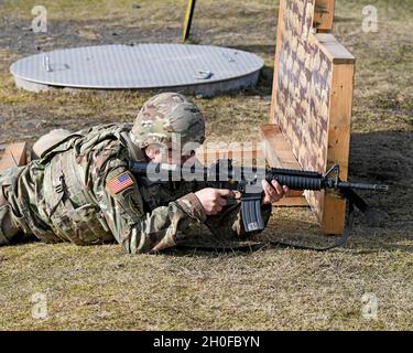 SGT. Prima classe Justin S. Rorex con 1 ° battaglione, 214 reggimento di aviazione, 12 ° combattimento brigata di aviazione, 'Wings of Victory,' durante un esercizio di fuoco dal vivo con M4 Carbine, subito dopo il fuoco, con un caso espulso a mezz'aria. Baumholder Maneuvre Training Area, Range 21, Germania 24 febbraio 2021. Foto Stock