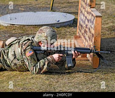 SGT. Prima classe Justin S. Rorex con 1 ° battaglione, 214 reggimento di aviazione, 12 ° combattimento brigata di aviazione, 'Wings of Victory,' durante un esercizio di fuoco dal vivo con M4 Carbine, subito dopo il fuoco, con un caso espulso a mezz'aria. Baumholder Maneuvre Training Area, Range 21, Germania 24 febbraio 2021. Foto Stock