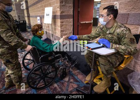 U.S. Air Force staff Sgt. David DeCarlo, a destra, 108th Wing, New Jersey Air National Guard, accetta una scheda di codice Quick Response da una persona che ha ricevuto la sua vaccinazione COVID-19 al COVID-19 Atlantic County Vaccination Mega-Site di Atlantic City, N.J., 25 febbraio 2021. Citizen-Airmen con la 108a ala e la 177a ala Fighter stanno assistendo gli operatori sanitari nello screening della temperatura, registrando e guidando gli individui attraverso le varie stazioni, e monitorando le persone dopo aver ricevuto le loro vaccinazioni. 2,881 persone sono state vaccinate quel giorno presso il sito. (New Jersey Foto Stock