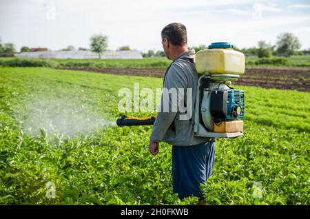 Oblast di Kherson, Ucraina - 22 maggio 2021: L'agricoltore spruzza una piantagione di patate con un irroratore. Efficace protezione del raccolto di piante coltivate contro insec Foto Stock