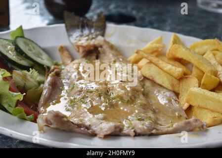 Trota intera grigliata con salsa alle erbe e patatine fritte Foto Stock