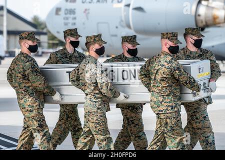 Una squadra di trasporto del corpo di Marina degli Stati Uniti trasporta una scatola di trasferimento di addestramento durante l'addestramento dignitoso di trasferimento di servizio congiunto con gli Airmen di affari di Mortuary dell'aeronautica militare di dover alla base di aeronautica militare, Delaware, 26 febbraio 2021. Le scatole di rinvio utilizzate durante l'addestramento vengono ponderate per simulare la caduta di un membro di servizio che indossa un equipaggiamento protettivo completo. Foto Stock