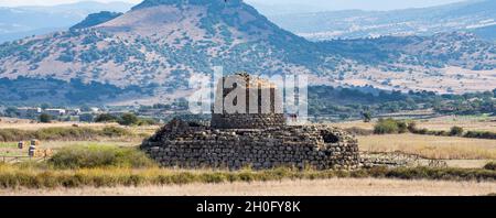 Paesaggio mozzafiato con l'antico nuraghe Santu Antine e alcune pecore al pascolo in primo piano. Foto Stock