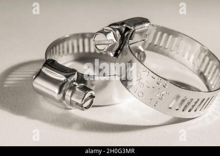 Primo piano astratto delle clip per tubo con attacco a vite senza fine Jubilee clip (queste non sono il vero marchio Jubilee). Per elementi di fissaggio fai da te, usi di metallo. Foto Stock
