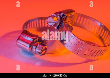 Primo piano astratto delle clip per tubo con attacco a vite senza fine Jubilee clip (queste non sono il vero marchio Jubilee). Per elementi di fissaggio fai da te, usi di metallo. Foto Stock