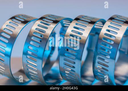 Primo piano astratto delle clip per tubo con attacco a vite senza fine Jubilee clip (queste non sono il vero marchio Jubilee). Per elementi di fissaggio fai da te, usi di metallo. Foto Stock