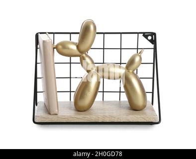 Piccolo scaffale appeso con figurine di cane palloncino su sfondo bianco Foto Stock