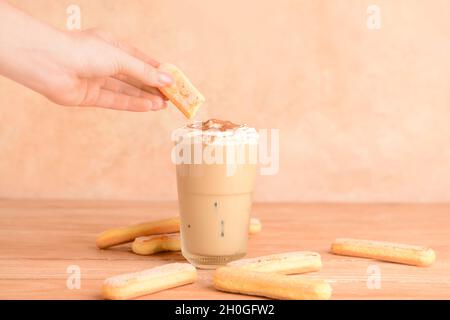Donna che prepara gustoso latte Tiramisu a tavola Foto Stock