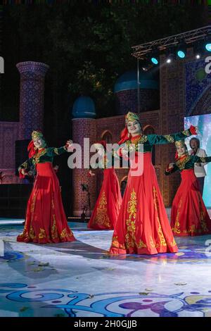 Ballerini femminili che si esibiscono in danze tradizionali per delegati di conferenze internazionali in una cena di gala, Tashkent, Uzbekistan Foto Stock