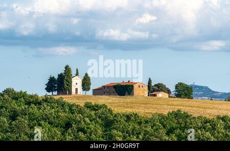 San Quirico d'Orcia, Toscana, Italia. Agosto 2020. L'affascinante Cappella della Madonna di Vitaleta in una bella giornata di sole. Cielo blu con clou bianco Foto Stock