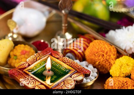 Argilla Diya Deep dia illuminata in Pooja Thali con fiore Genda, Ghanti e Sankh. Diwali, Capodanno, Navratri, Dussehra Puja, Deepawali, Karva Chauth, Foto Stock