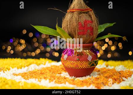 Terracotta Clay Pot Kalash decorato con cocco, foglia di mango posto su Rangoli fiore di Marigold. Usato in Navratri Pooja, Dussehra Puja, Karva Chaut Foto Stock
