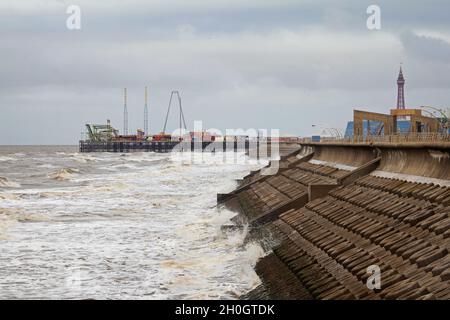 Guardando lungo una parte delle difese marine di Blackpool in alta marea, in una giornata di nebbia. Foto Stock