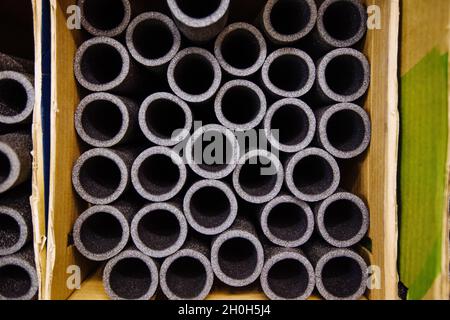 Isolamento impilato per tubi in polietilene espanso in magazzino. Foto Stock